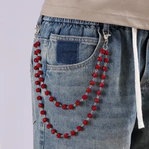 Detalle de cadena de cintura punk de doble capa con cuentas de cristal rojo en vaqueros