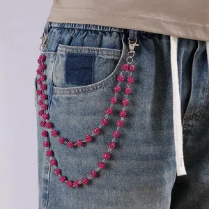 Detalle de cadenas dobles de cuentas rosas con diamantes y cierres de plata en vaqueros