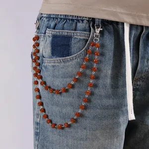 Detalle de cadena de pantalón de doble capa con cuentas de ámbar y cierres de langosta