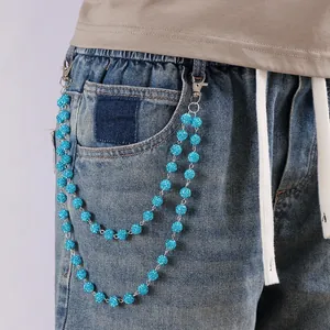 Detalle de la cadena de cintura de doble capa con cuentas azules brillantes en jeans