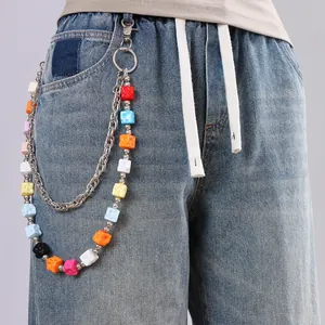 Detail of double-layer pants chain featuring colorful cheese block charms on blue jeans