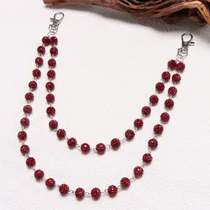 Detalle de cadena de cintura de doble hilera con bolas rojas decoradas con diamantes
