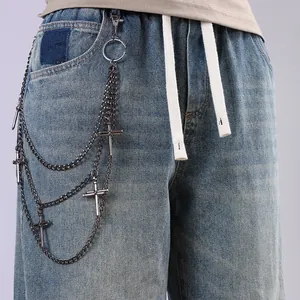 Detail of hip-hop multi-layer metal pants chain with cross pendants on blue denim