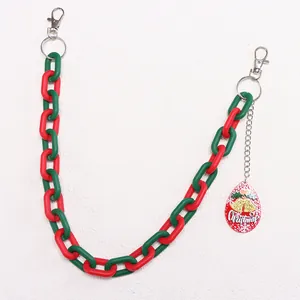 Macro detail of red and green acrylic chain with Christmas charm and metal lobster clasps