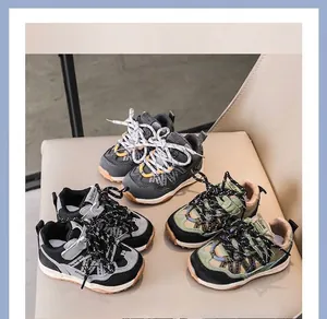 Gros plan de baskets pour enfants à semelles épaisses en gris et vert sur chaise