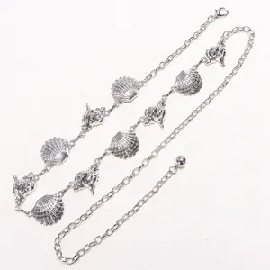 Detail of silver metal waist chain with realistic seashell and conch charms and lobster clasp