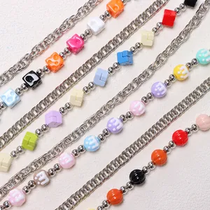 Close-up of colorful resin cubes and metal chain layers on a trendy trouser chain