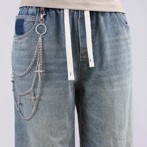 Detail of silver multi-layer punk hip hop pants chain with three cross charms on denim