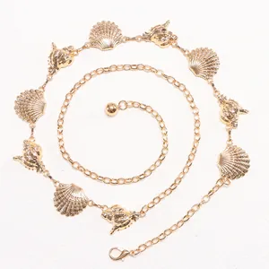Detail of golden metal waist chain with seashell and conch charms in spiral layout