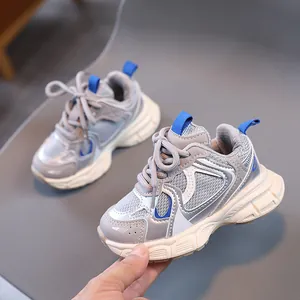Detail of children's chunky sneakers with breathable mesh, grey-blue accents, and soft sole