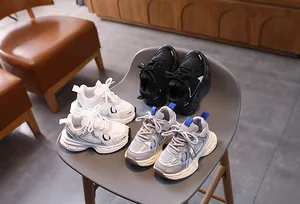 Detail view of kids' chunky sneakers in white, black and grey with non-slip soft soles