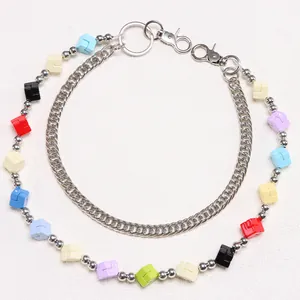 Close-up of colorful cube beads and silver Cuban chain layers with lobster clasp detail