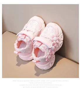 Close-up of girls' pink sneakers featuring daisy floral accents and breathable mesh