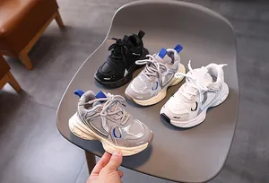 Detailed overhead view of kids' chunky sneakers in black, silver, and white mesh