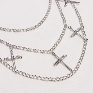 Detail of silver layered metal pants chain with cross-nail pendants in punk hip hop style