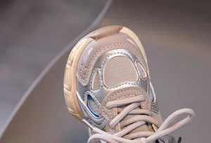 Detailed close-up of kids sneakers showing mesh fabric and silver synthetic leather stitching