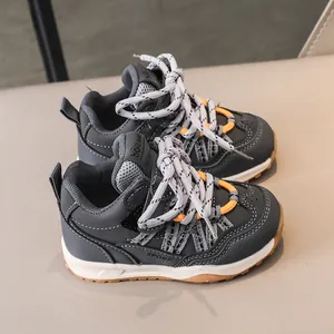 Détail de baskets grises pour enfants avec mesh respirant et accents orange vif