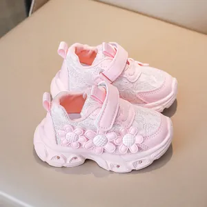Close-up of pink girls sneaker featuring lace texture, 3D floral accents, and velcro strap