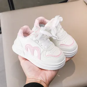 Detailansicht der rosa-weißen Kinderschuhe mit M-Logo und dicker Gummisohle
