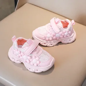 Detailed close-up of pink toddler sneakers featuring 3D floral accents and velcro straps
