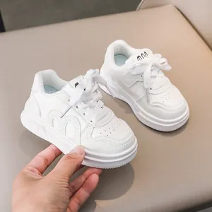 Detail der weißen Kindersneaker mit Wellennähten, perforiertem Leder und robuster Gummisohle