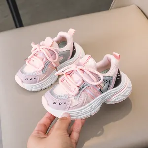 Detail view of pink breathable mesh kids sneakers with thick white rubber soles and sport tags