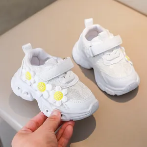Close-up of girls' white floral sneakers showing velcro strap and breathable mesh