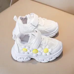 Detailed macro view of white girls' sneakers featuring 3D daisies and lace textures