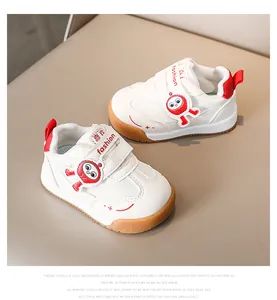 Dettaglio di scarpe bimbi bianche con inserti rossi e suola in gomma marrone