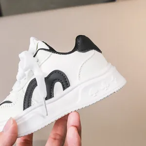 Nahaufnahme weißer Kinder-Sneaker mit strukturierten geometrischen Mustern auf der dicken Sohle