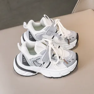 Detail of children's white and grey sneakers with breathable mesh and velcro closure