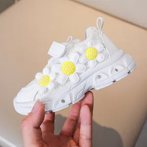 Detailed shot of girls' white lace sneakers with 3D daisies and velcro closure