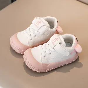 Detail view of baby sneakers featuring pink rubber toe cap and cute pom-pom heel decor