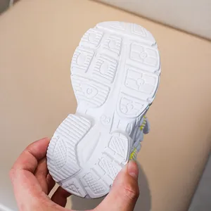 Detail of white non-slip sole with geometric patterns and size 23 mark on kids sneakers