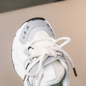 Detail of breathable mesh fabric and sporty synthetic overlays on kids sneakers