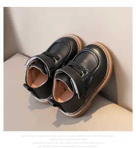 Detail of toddler black faux leather shoes with velcro strap and soft gum sole