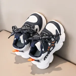 Détail de baskets pour enfants avec mesh contrasté bleu marine et orange et semelle épaisse