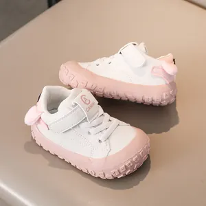 Detail of baby sneakers showing non-slip pink rubber sole and plush heel ball decoration