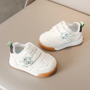 Dettaglio delle sneakers bianche per bambini con suola in gomma e chiusura a strappo
