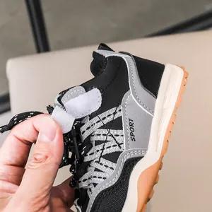 Détail de baskets en cuir pour enfants avec fermeture à scratch et logo sport blanc
