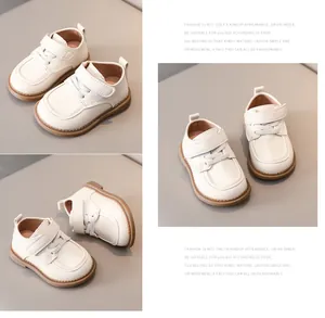 Detail of white leather baby loafers showing hook-and-loop closure and non-slip sole