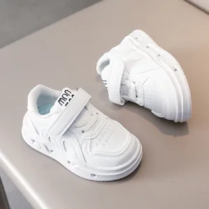 Détail de baskets blanches pour enfants avec velcro et bout perforé respirant