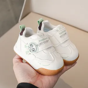 Dettaglio di scarpe sportive per bambini con velcro, toppe cartoon e suola in gomma antiscivolo