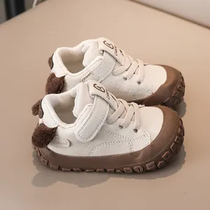 Close-up of baby walking shoes featuring cream and brown leather with velcro straps