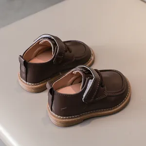 Detail view of toddler dark brown leather shoes with anti-slip rubber sole and velcro strap