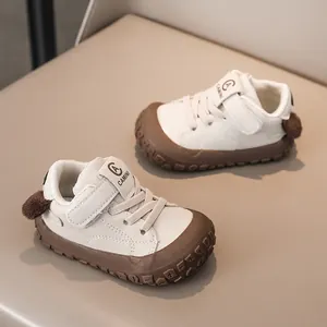 Detail view of anti-slip rubber sole and cute brown fur ball on baby sneakers