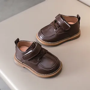 Detailed top view of dark brown toddler leather shoes with velcro strap and non-slip sole