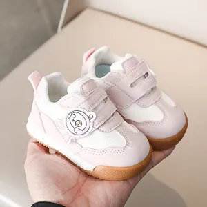 Dettaglio di scarpe rosa per neonati con patch orsetto, velcro e suola in gomma