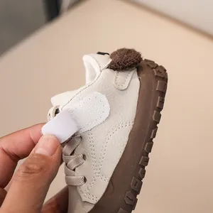 Detail showing the velcro closure on beige toddler shoes with durable rubber sole