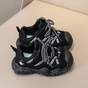 Vista dall'alto di scarpe sportive nere per bambini con rete traspirante e suola robusta